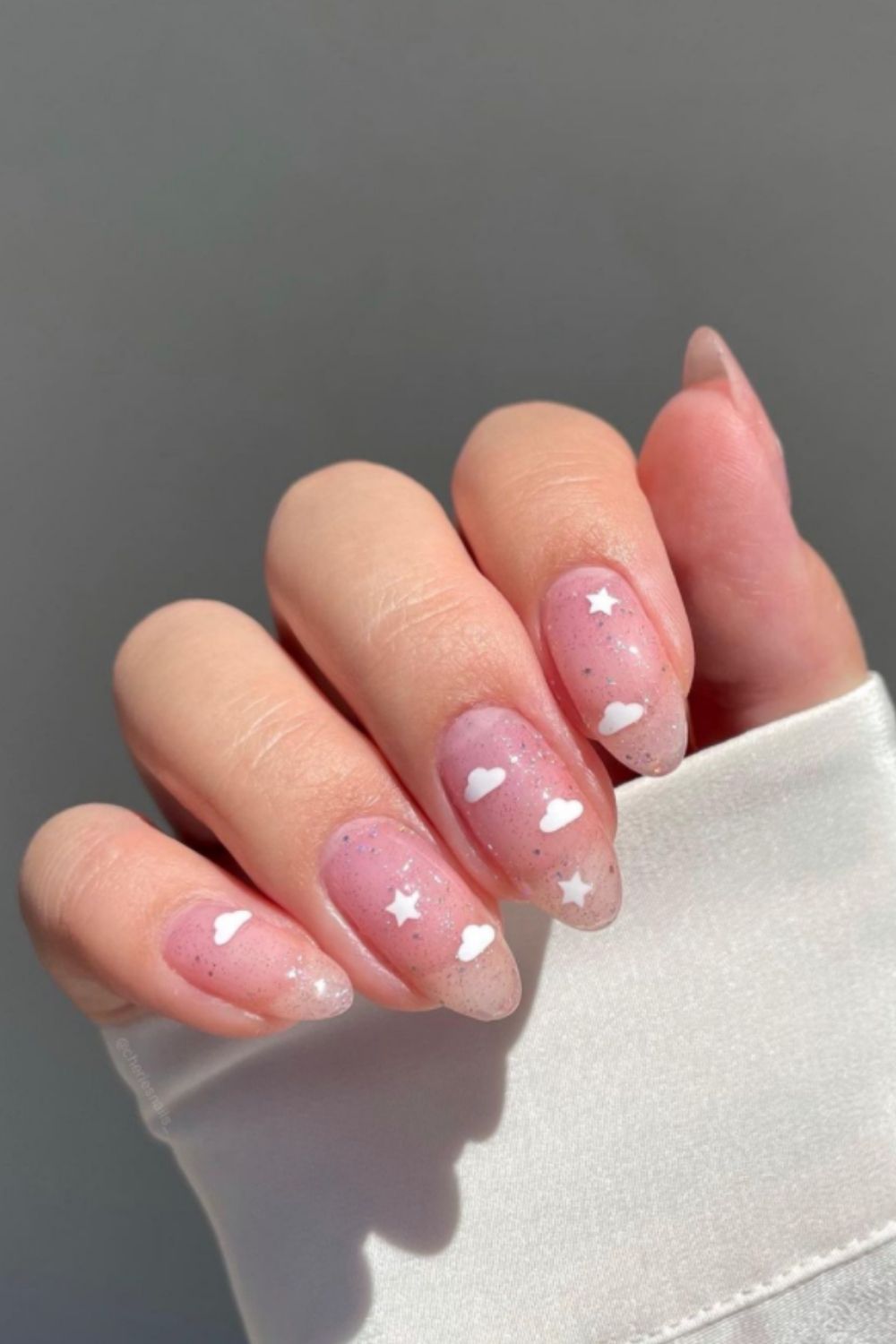 Glitter almond nail ideas with white clouds and stars
